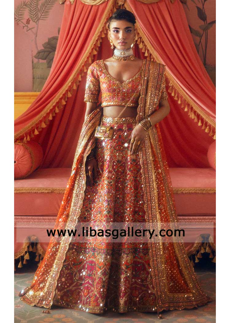 orange raw silk choli and a heavily embellished skirt with intricate mirror work